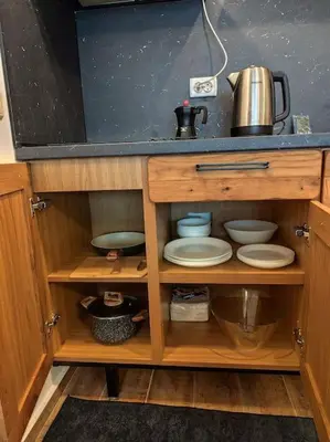 a wooden cabinet with plates and dishes in it at Only You Boutique Apartment in Sofia