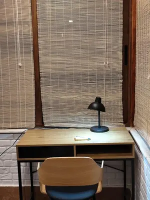 a desk with a lamp and a chair in front of a window at Only You Boutique Apartment in Sofia