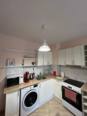 a kitchen with white cabinets and a washing machine at Уютен тристаен апаратамент,намиращ се на тиха и спокойна улица in Sofia