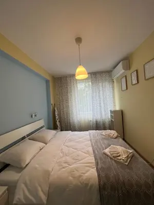 a bedroom with a large white bed with a window at Уютен тристаен апаратамент,намиращ се на тиха и спокойна улица in Sofia