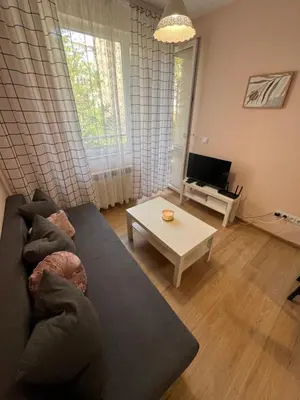 a living room with a couch and a table at Уютен тристаен апаратамент,намиращ се на тиха и спокойна улица in Sofia