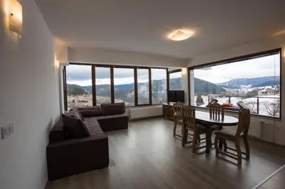 a living room with a couch and a table and chairs at Guest House Panorama in Gela