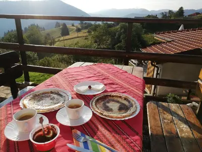 a table with two plates of food and cups of coffee at Guest House Panorama in Gela