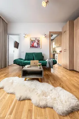 a living room with a green couch and a rug at Vespa Home Boutique Apartment in Sofia