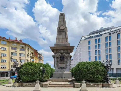 a monument with a clock on it in a city at Vespa Home Boutique Apartment in Sofia