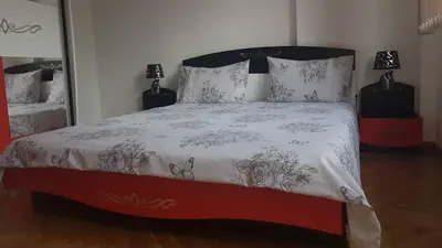 a bedroom with a bed with a black and white comforter at Kyurkchievi Guest House in Sapareva Banya