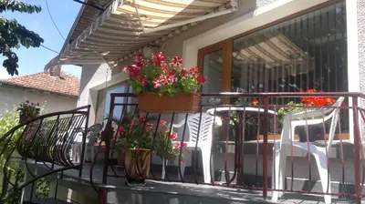 a balcony with flowers in a pot on it at Kyurkchievi Guest House in Sapareva Banya