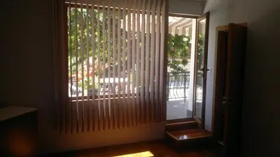 a room with a door with a window with wooden blinds at Kyurkchievi Guest House in Sapareva Banya