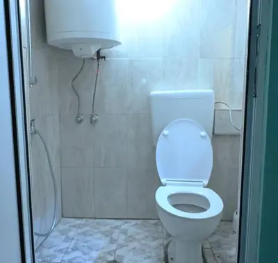 a bathroom with a white toilet and a shower at National Theatre Loft in Sofia