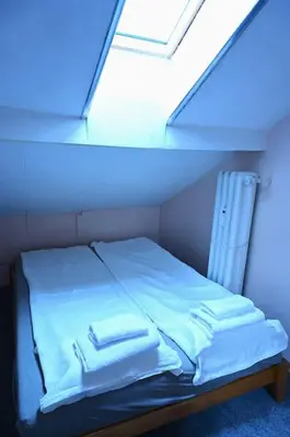 a bed in a room with a blue light at National Theatre Loft in Sofia