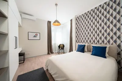 a bedroom with a large white bed with blue pillows at Top Centre Bright & Sunny Stylish Apt with 2BDR and 2BTH in Sofia