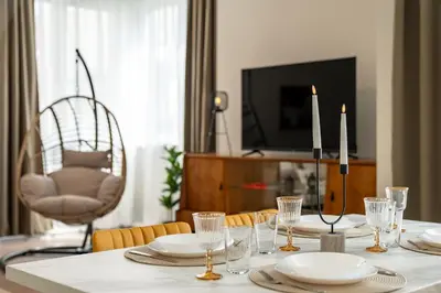 a dining room table with plates and candles and a television at Top Centre Bright & Sunny Stylish Apt with 2BDR and 2BTH in Sofia