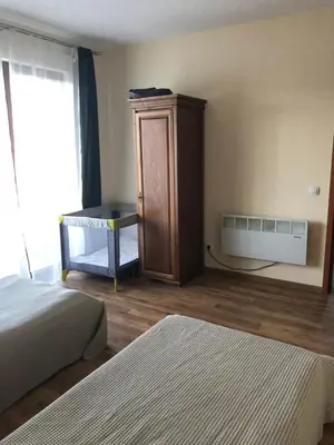 a bedroom with two beds and a cabinet and a window at Spacious 2 Bed Apartment Close To Gondola in Bansko