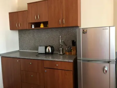 a kitchen with wooden cabinets and a stainless steel refrigerator at Spacious 2 Bed Apartment Close To Gondola in Bansko