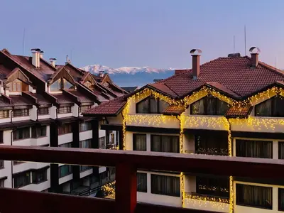 a building with a red roof with christmas lights at Spacious 2 Bed Apartment Close To Gondola in Bansko