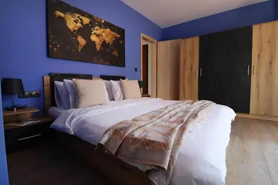 a bedroom with a large bed with blue walls at New Sofia Sunset 1BDRM, Free Parking and Terrace in Sofia