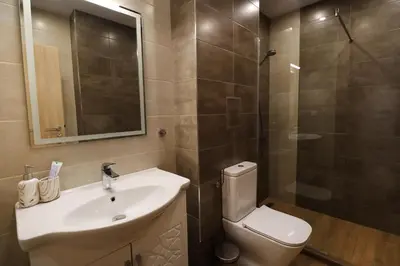 a bathroom with a toilet and a sink and a shower at New Sofia Sunset 1BDRM, Free Parking and Terrace in Sofia