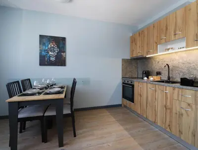 a kitchen with a table with chairs and a sink at New Sofia Sunset 1BDRM, Free Parking and Terrace in Sofia