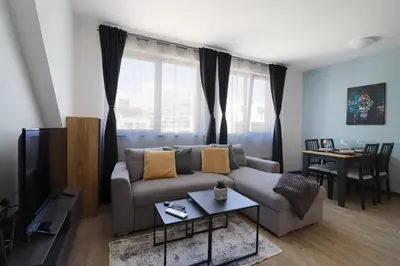 a living room with a couch and a table at New Sofia Sunset 1BDRM, Free Parking and Terrace in Sofia