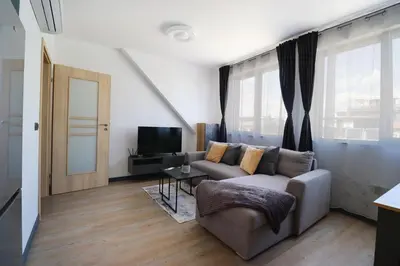 a living room with a couch and a tv at New Sofia Sunset 1BDRM, Free Parking and Terrace in Sofia