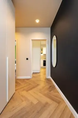 an empty hallway with wood floors and a mirror at Olive Green Designer Apartment in Plovdiv