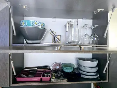a shelf with dishes and a sink in a kitchen at Apartment with veranda in Bansko