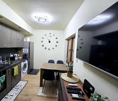 a kitchen with a table and a clock on the wall at Apartment with veranda in Bansko