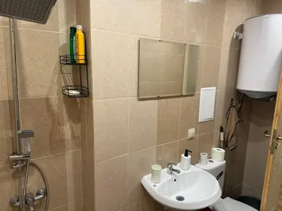 a bathroom with a sink and a toilet and a mirror at Simple and Affordable Apartment in Bansko with available parking space in Bansko