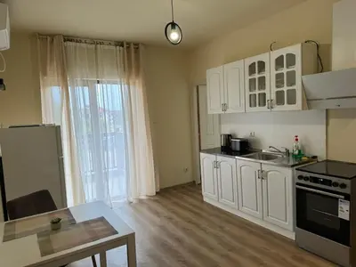 a kitchen with white cabinets and a counter top at Simple and Affordable Apartment in Bansko with available parking space in Bansko