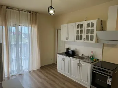 a kitchen with white cabinets and a sink at Simple and Affordable Apartment in Bansko with available parking space in Bansko