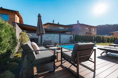 a patio with a table and chairs and an umbrella at Aqua Thermal Villa Banya in Banya