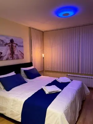 two beds in a bedroom with a blue light at Blue Orchid Studio near airport & free parking in Sofia