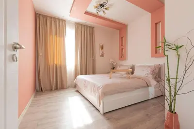 a bedroom with a bed and a large window at Домът на Билкарката in Plovdiv