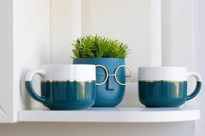 three coffee mugs sitting on a shelf with glasses at Домът на Билкарката in Plovdiv