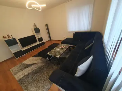a living room with a blue couch and a table at Levkov in Petrich