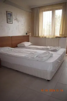 a large bed in a bedroom with a window at Villa Park Guest Apartments in Borovets