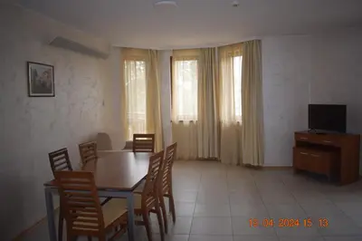 a dining room with a table and chairs and a television at Villa Park Guest Apartments in Borovets