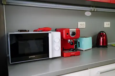 a microwave on a kitchen counter with a red appliance at 7 Seconds Away From the Main Street, FREE Parking in Sofia