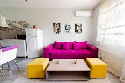 a living room with a pink couch and a table at Апартамент Веирас 2 in Velingrad