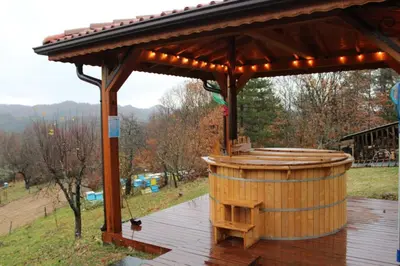 a wooden gazebo with a barrel on a deck at Вила Белият камък - Златоград in Zlatograd