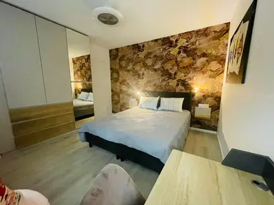 a bedroom with a bed and a stone wall at Apartament-DEMIAN in Sofia