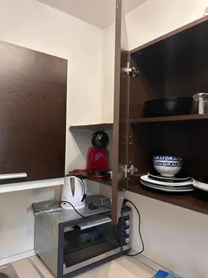 a kitchen with an open cupboard with a microwave at B7 Luxury Studio Apartment in Green Life Bansko in Bansko