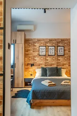 a bedroom with a brick wall and a bed at BB Apartment in Sofia