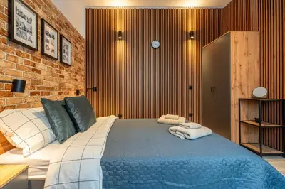 a bedroom with a large bed in a brick wall at BB Apartment in Sofia