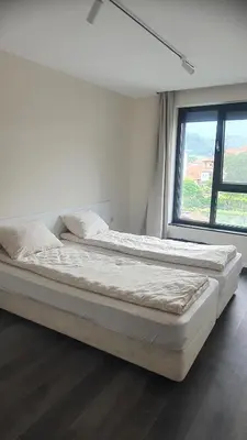two beds in a white room with a window at Panorama view apartment in Gotse Delchev