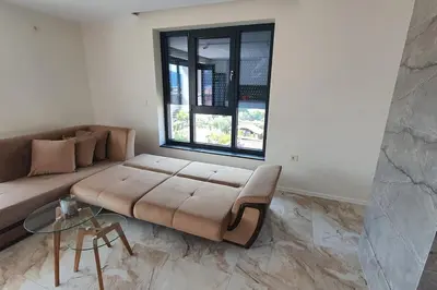 a living room with a couch and a window at Panorama view apartment in Gotse Delchev