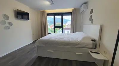 a bedroom with a bed and a large window at Panorama view apartment in Gotse Delchev
