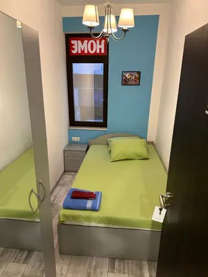 a small bedroom with a green bed and a snoot sign at Comfort Guest Rooms in Plovdiv
