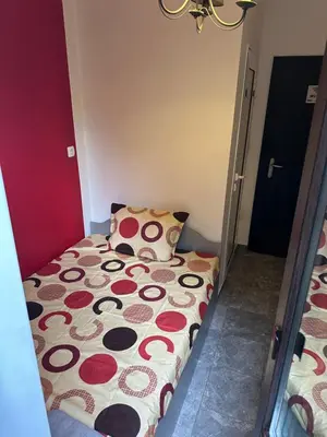 a small bedroom with a bed with polka dots at Comfort Guest Rooms in Plovdiv
