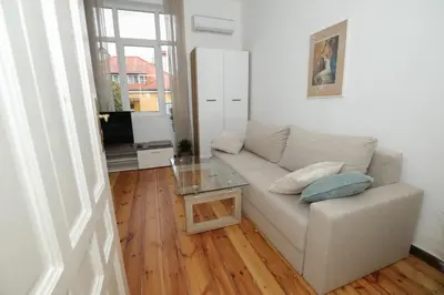 a living room with a couch and a glass table at Уютна къща в сърцето на София in Sofia